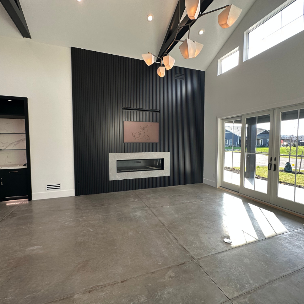 Vaulted great room with linear fireplace and slatted black feature wall