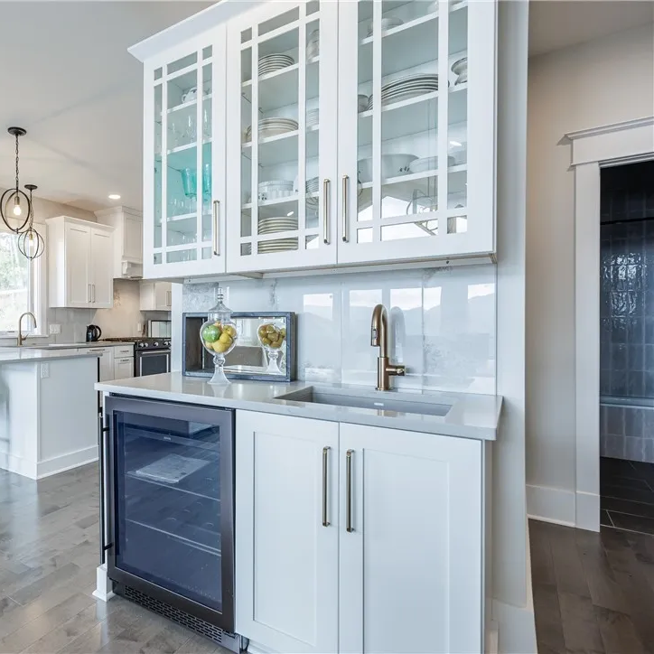 Wet bar with glass-front cabinetry, beverage cooler, and prep sink