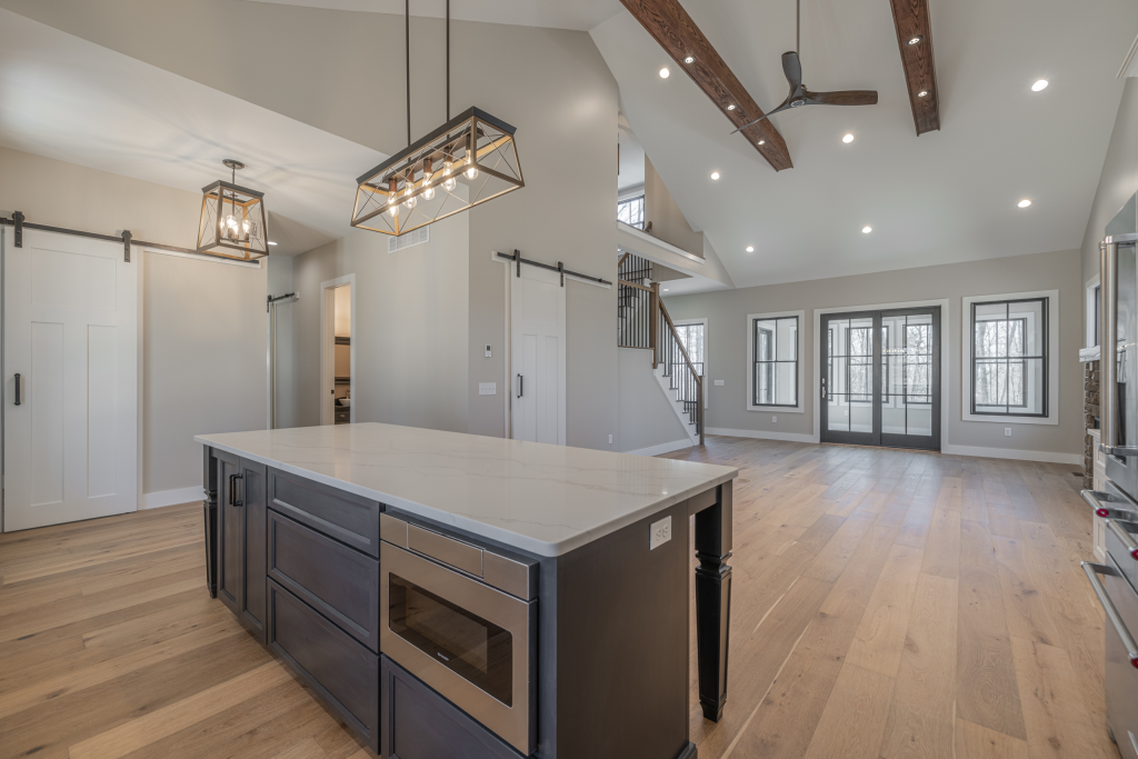 Open kitchen island beneath a vaulted ceiling with timber beams