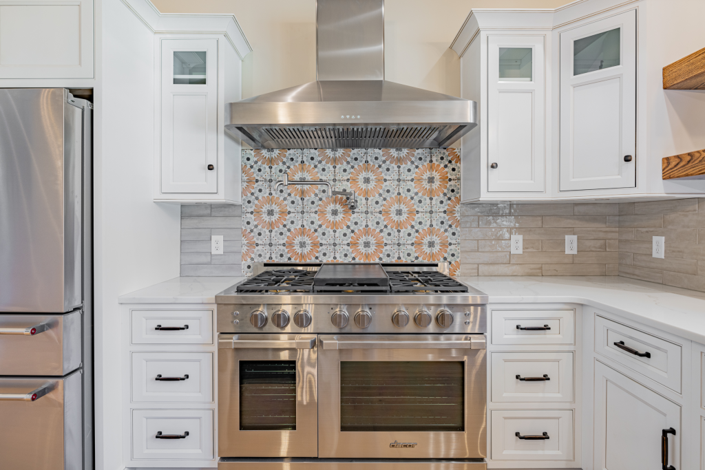 Range wall with patterned tile backsplash and stainless hood