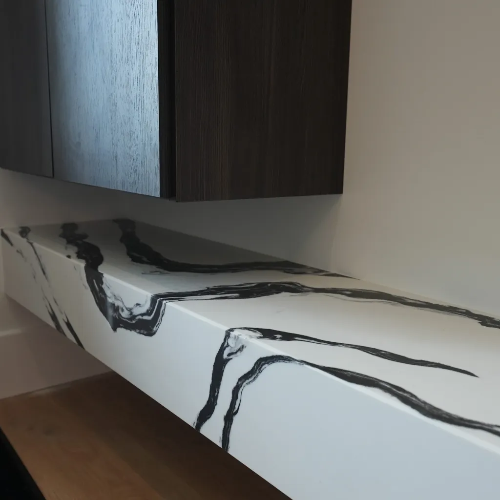 Wet bar counter detail with veined stone and dark wood cabinetry