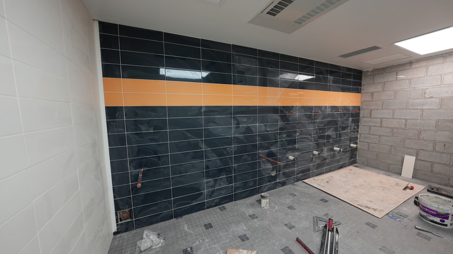 New tile work in a locker room under construction on an Iversen Construction project