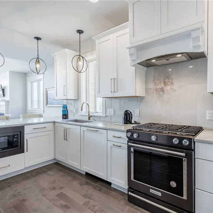 Chef's kitchen with marble countertops, gas range, and custom hood