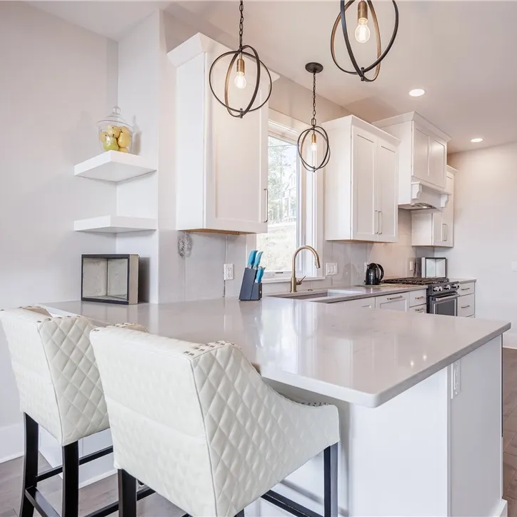 Kitchen peninsula seating with pendant lighting and floating shelves