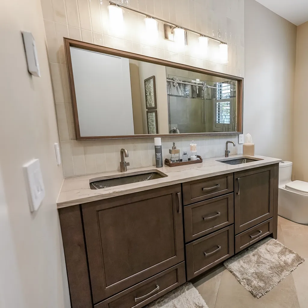 Double vanity bath with marble counter and framed wood mirror