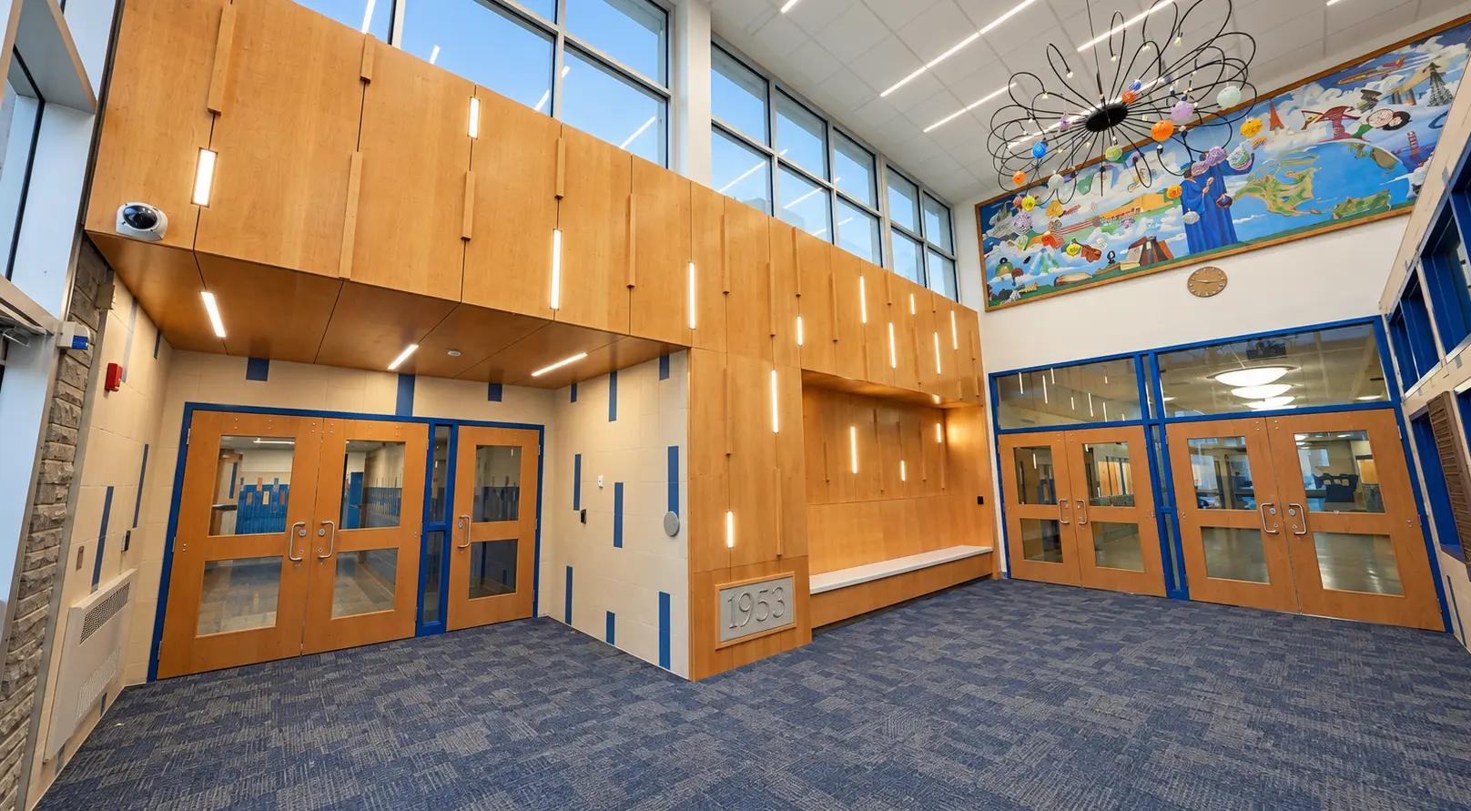 Renovated lobby with custom wood millwork and doors at Bath Central School District