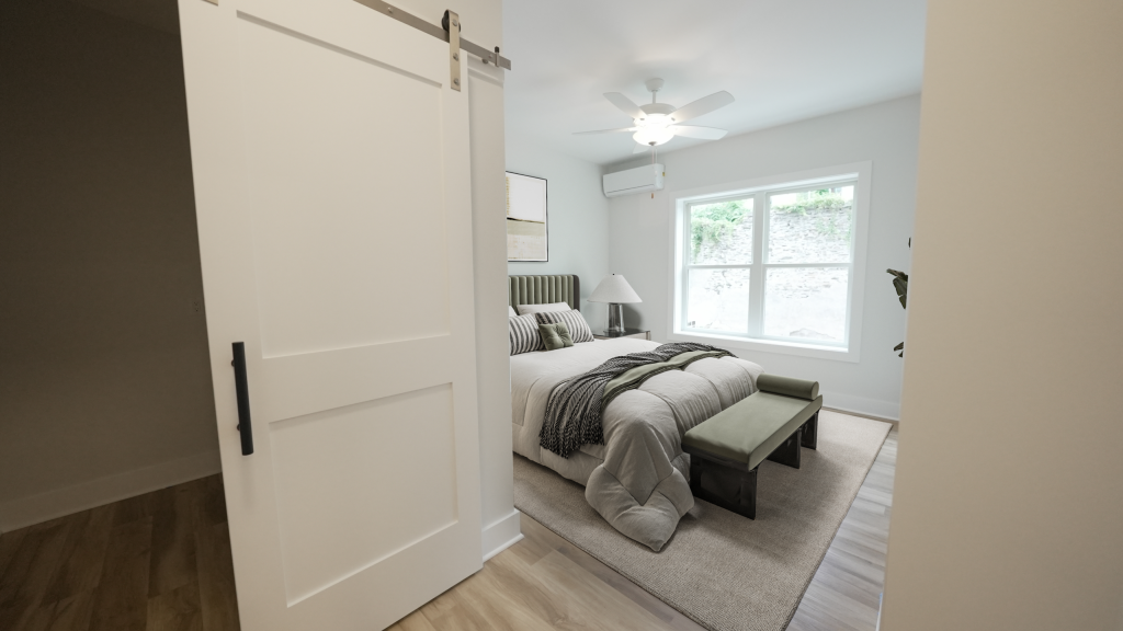 Guest bedroom with barn door and wide-plank flooring